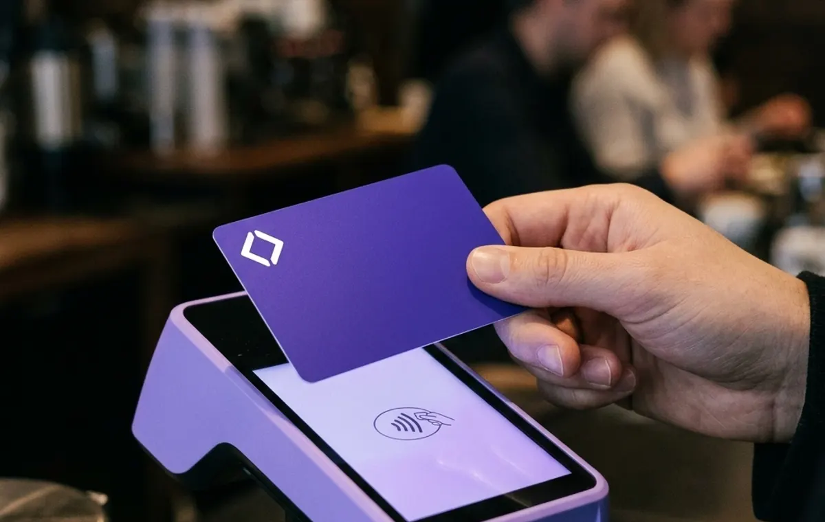 Рука прикладывает карту Nexus Pay к платёжному терминалу в кафе